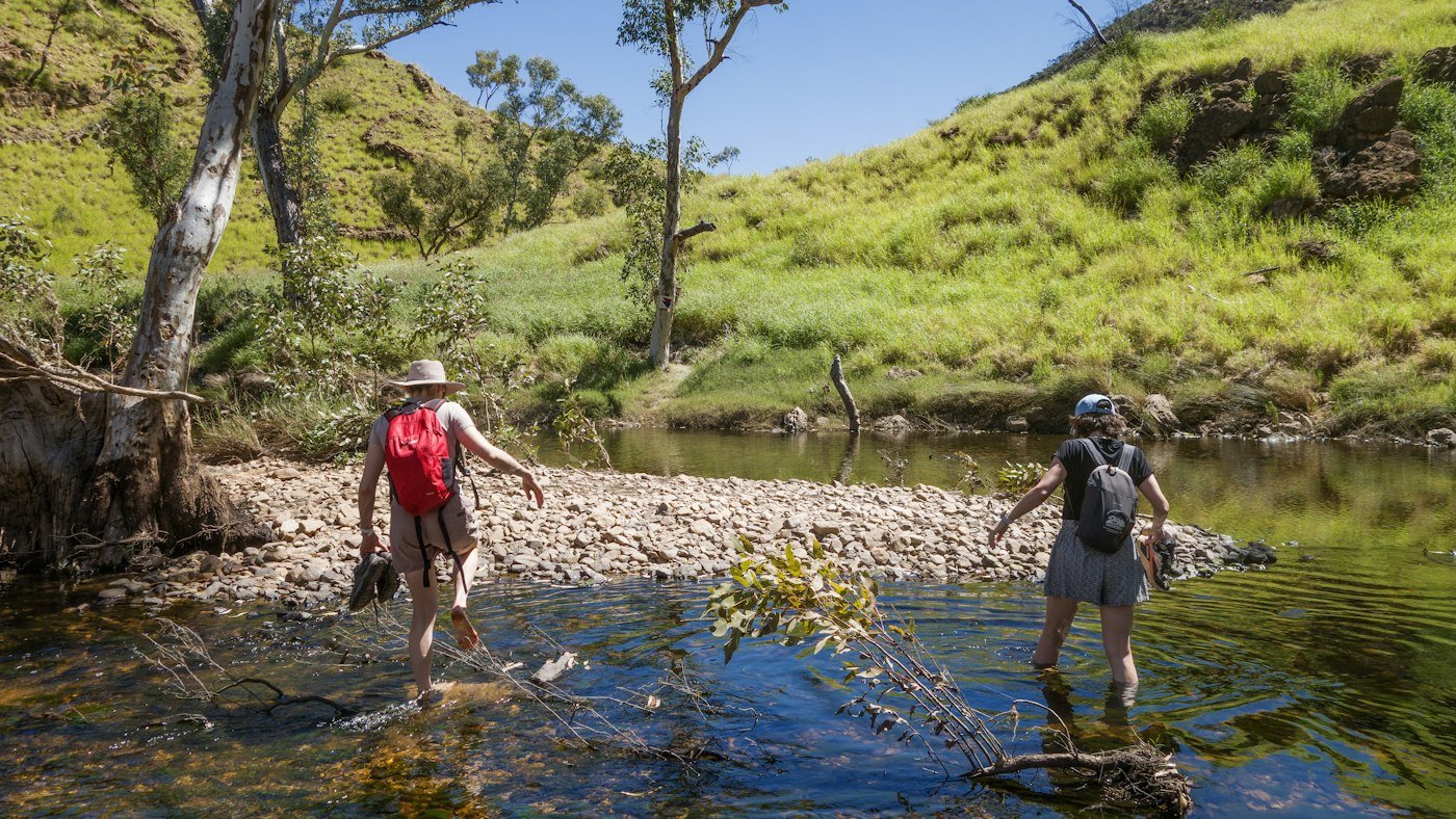 Familia riendo en la orilla de un río de montaña al atardecer
